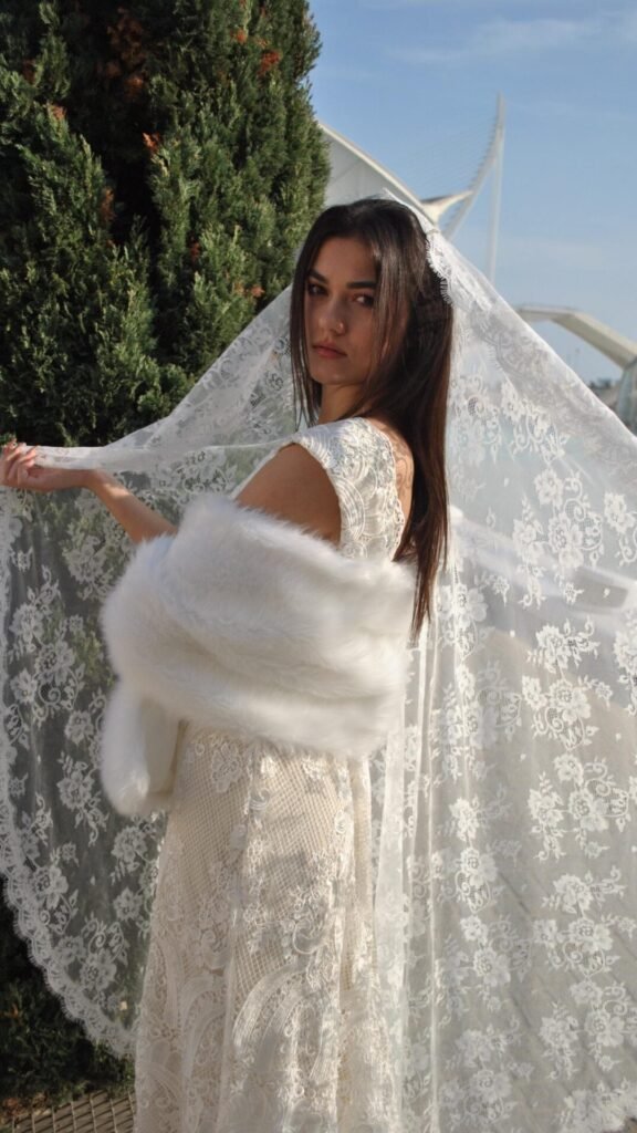 Bride wearing a light ivory embroidered lace mantilla wedding veil outdoors