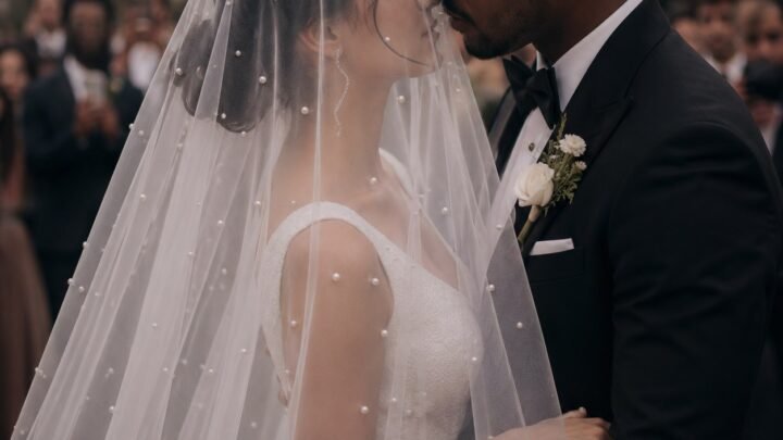 Bride wearing the pearl veil blusher over her face during the wedding ceremony