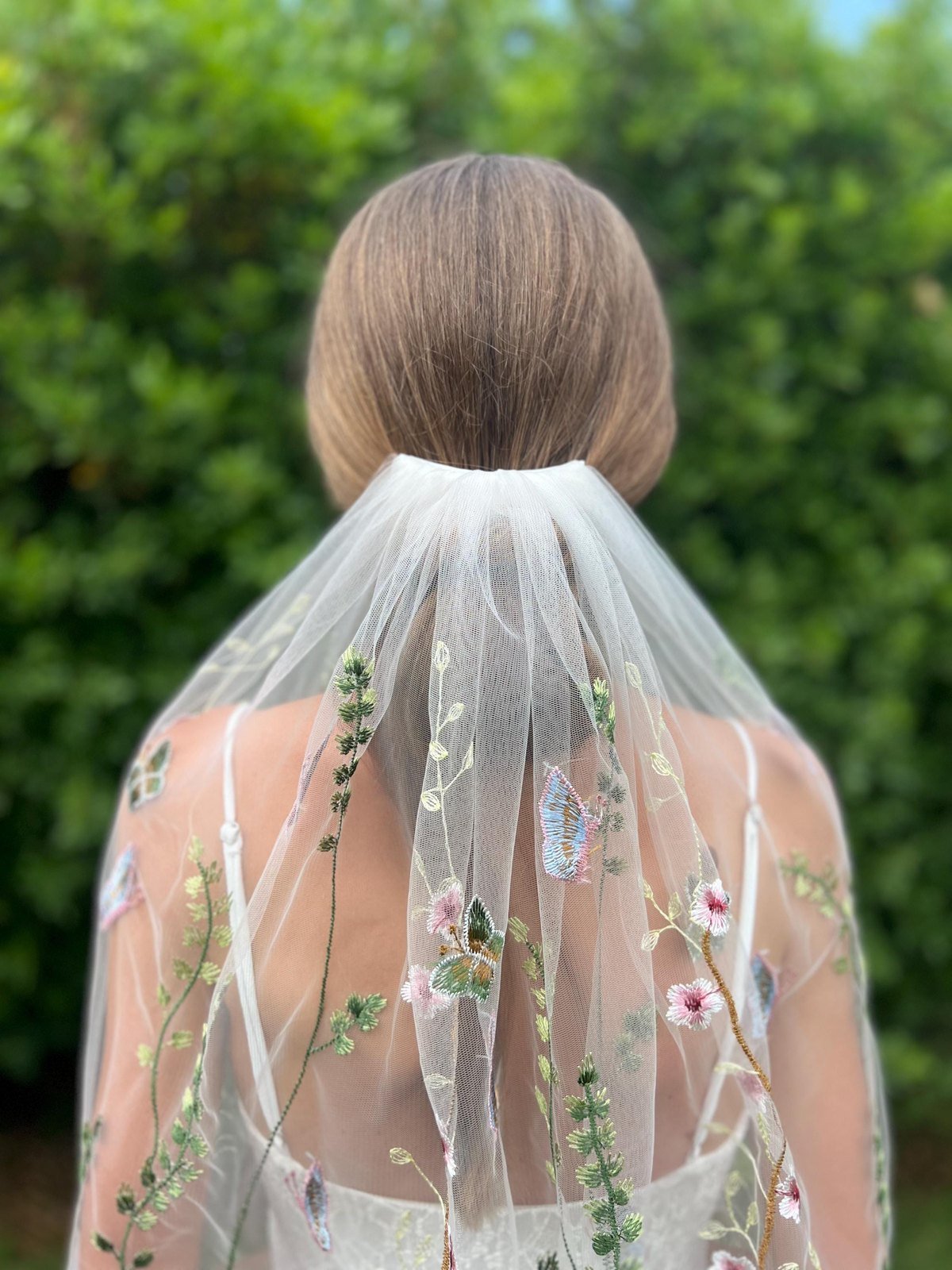 Close-up back view of wildflower wedding veil gathered at the comb
